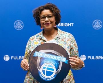 Lesha Greene holding Fulbright Top Producer sign