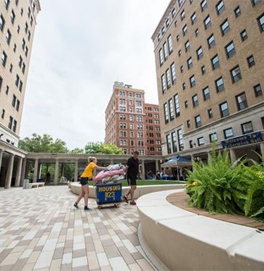 A student volunteer helps another student move into a Pitt campus dormitory.