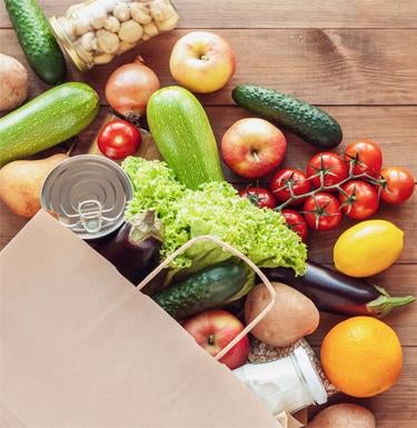 A bag full of vegetables is emptied onto a table.