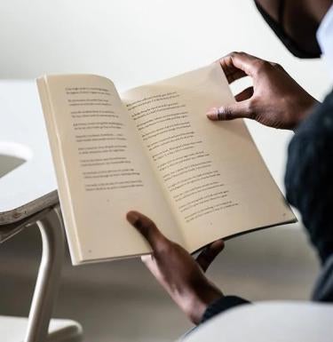 Student reading poetry book.