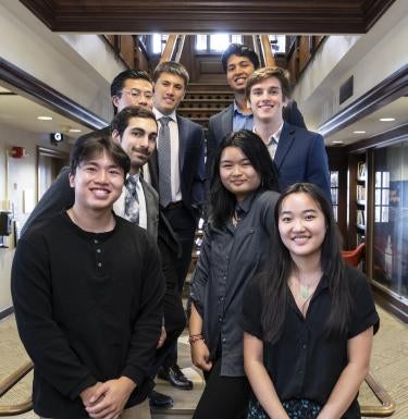 Students who participated in the SHURE-Grid program stand on the stairs of the David C. Frederick Honors College