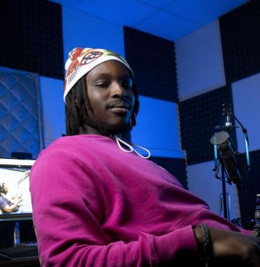 Podcaster Ian Kehinde sitting in the recording studio.