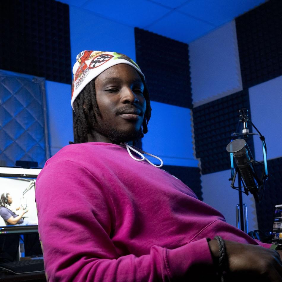 Podcaster Ian Kehinde sitting in the recording studio.