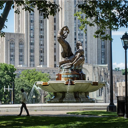 Person walking in front of Frick Fine Arts fountain